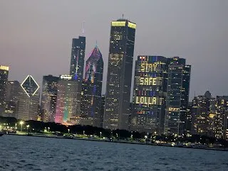 Chicago skyline at dusk, with the buildings lit up in celebration of Lollapalooza