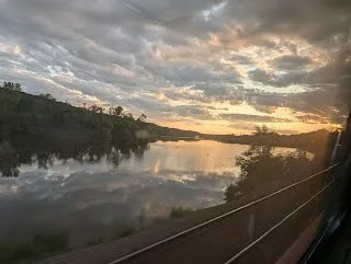 Golden sunset reflected on the Hudson River, viewed from the train window