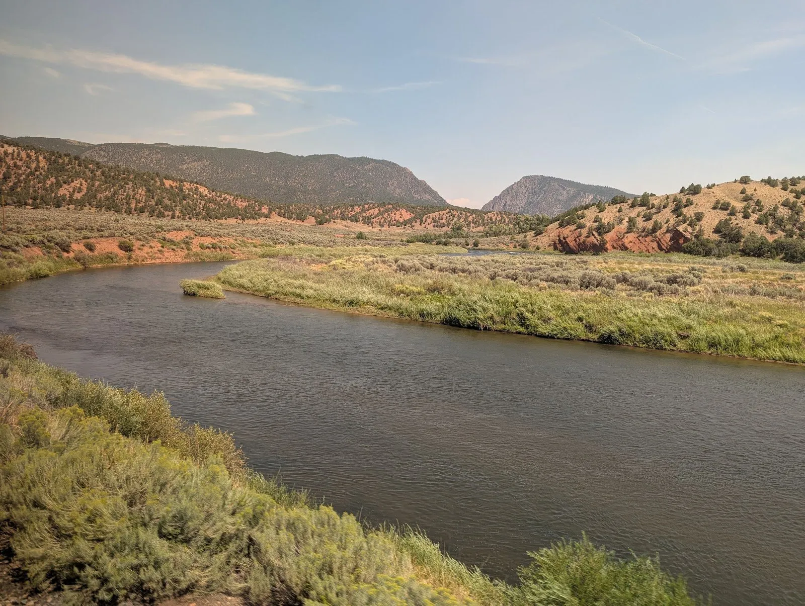 Groups of rafters and kayakers navigating the Colorado River, as seen from the train