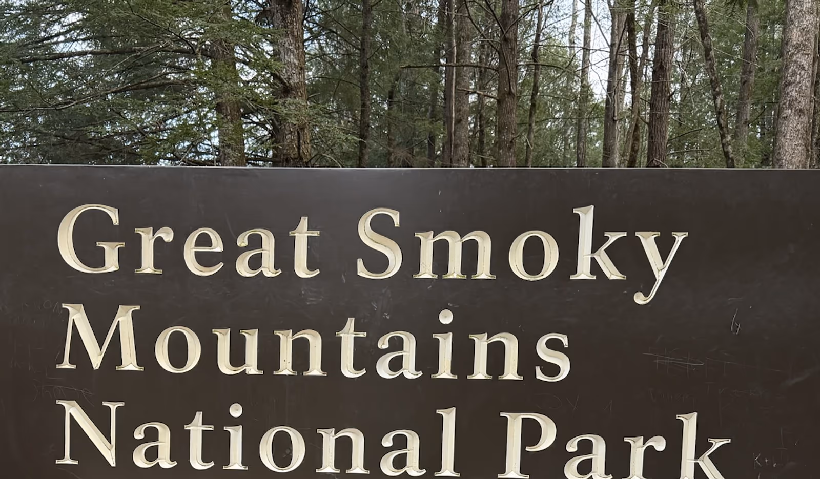 Family standing near the Great Smoky Mountains National Park sign
