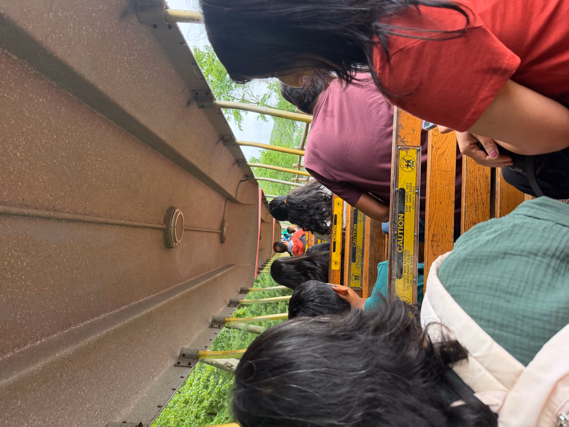 Back-seat view from the Turtle Back Zoo train ride with riders seen from behind