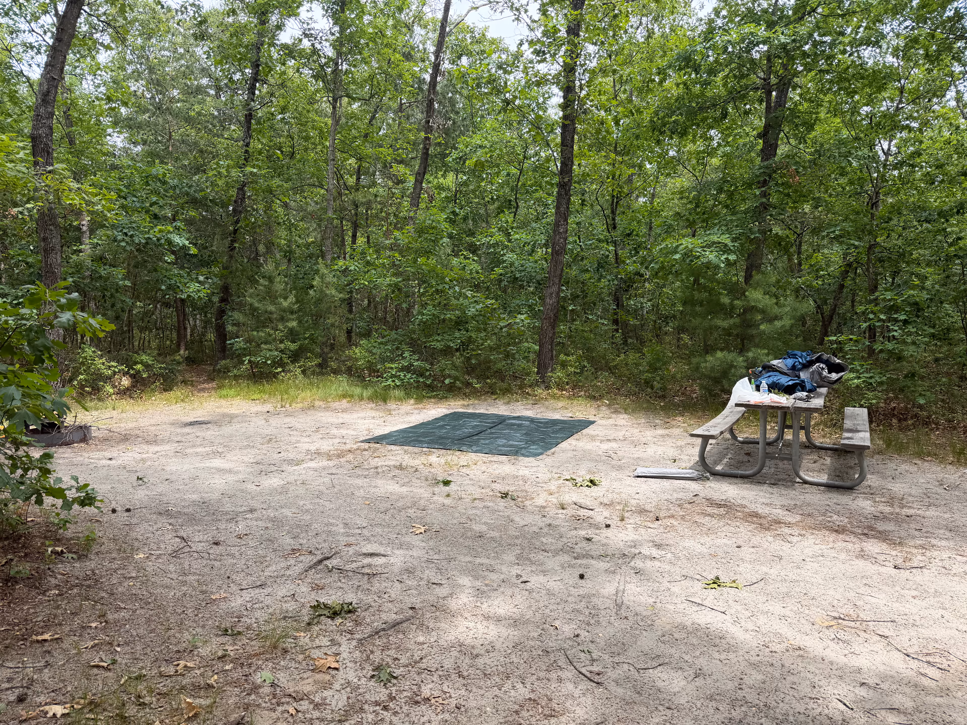 Empty Atsion campsite with a ground tarp and picnic table before the tent was set up