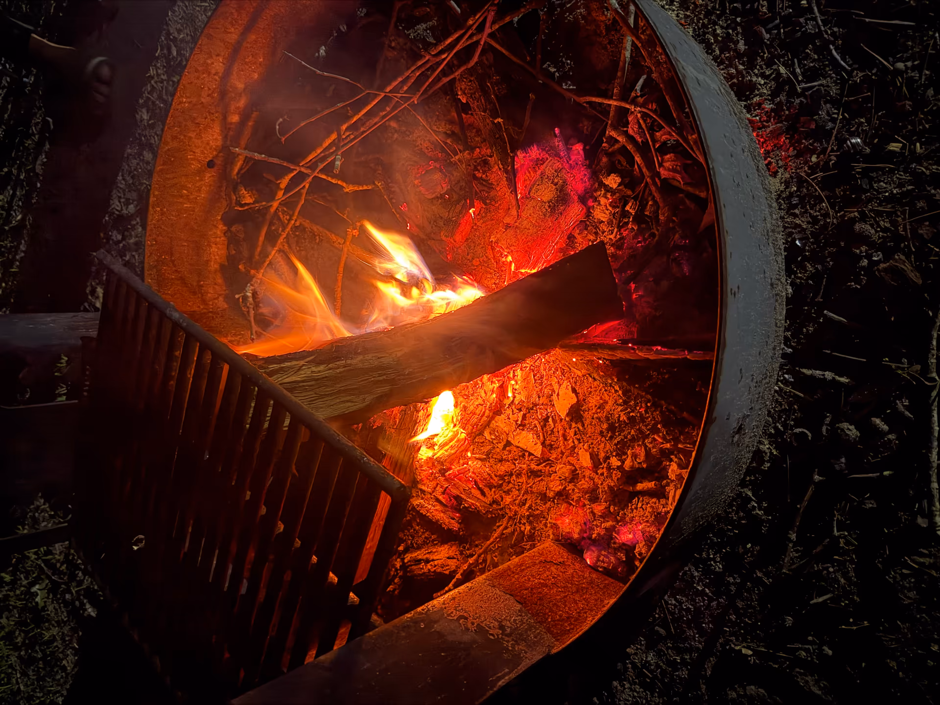 Campfire burning inside the campsite fire ring at night